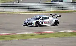 Voiture GT grise, vue de trois-quarts, en pleine ligne droite.