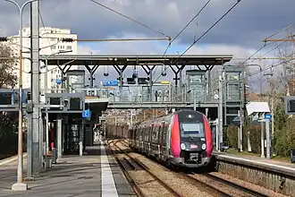 Cliché en couleur. Visualisation de deux quai. Une rame automotrice se trouve à l'un d'eux.