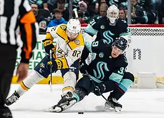 Tommy Novak disputant un palet à Ryker Evans lors d'un match face au Kraken de Seattle.