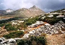 photographie : paysage de pierres : une statue inachevée est couchée sur le dos