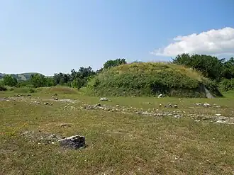 La reconstitution d'un monticule. À l’intérieur se trouvent une salle polyvalente et une reproduction d’une chambre funéraire.