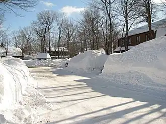 La neige abondante au Québec durant l'hiver 2007-2008 cause des problèmes de déneigement et crée des accumulations importantes devant les maisons.