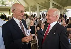 Photographie couleur de Collins et Aldrin se parlant lors d'une cérémonie.