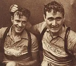 Photo en noir et blanc montrant deux cyclistes professionnels assis l'un à côté de l'autre et souriants.