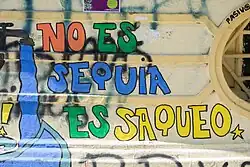 Slogan « No es sequía es saqueo » taggé en espagnol sur un mur.