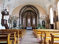 Vue intérieure de la nef vers le chœur avec la chaire et les autels (XIXe).