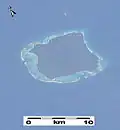 Détail d'une image de la NASA prise en 2003 (à partir de la Station spatiale internationale) de l'île de North Sentinel, la barrière corallienne qui entoure l'île peut être vue clairement. Cette image date d'avant le tsunami de 2004, qui a causé le soulèvement de l'île et l'exposition d'une grande partie du récif.