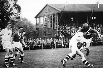 Photographie en noir et blanc d'une scène d'un match de football.