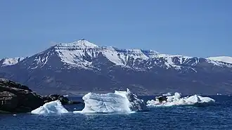 Qilertiinguit Kangilequtaa (2&nbsp;070&nbsp;m) vu d'Uummannaq à travers le bras principal du fjord Uummannaq.