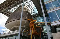 Photographie d'un bâtiment moderne composé de plusieurs parties, en verre et en bois.