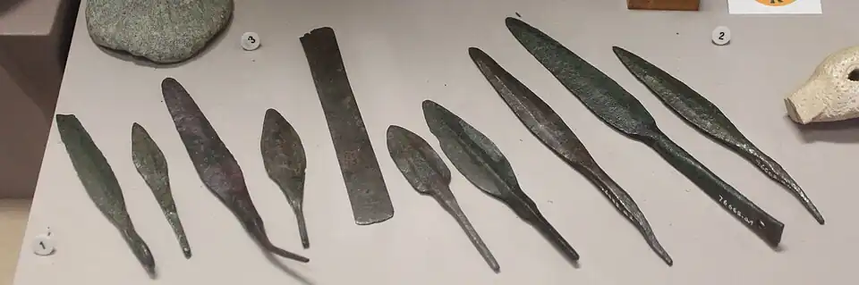 Divers objets en bronze provenant de Ras Shamra : pendeloques, épingles, plaquettes, pointes de flèches et de lances. Musée d'archéologie nationale.