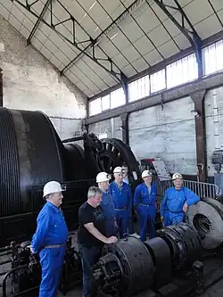 Un groupe d'anciens mineurs devant les machines.