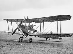 Photo noir et blanc d'un avion biplan au sol.