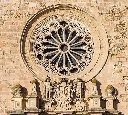 Détails de la façade de la cathédrale : la rosace et les armes de la ville entourée de deux chérubins.