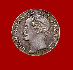 Pièce de monnaie de couleur argentée montrant le profil d'un homme moustachu.