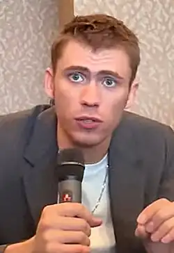 Homme aux yeux bleus avec un microphone.