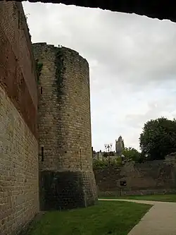 Rempart et tour. En arrière-plan, une église.
