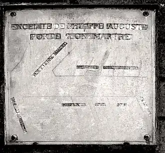 Plaque historique avec le tracé (effacé) de la porte.