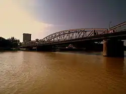 Vue d'un grand pont métallique passant au-dessus d'un fleuve.