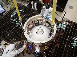 Photo prise dans une salle blanche montrant l'étage de croisière entouré de techniciens.