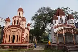 Rue avec deux bâtiments colorés dans des teintes blanches et beiges.