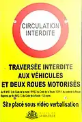 Panneau informant de l'interdiction de circuler à certains véhicules sur la place Jean-Jaurès. Il indique : « Circulation interdite. Traversée interdite aux véhicules et deux-roues motorisés. Art. R 412-7 2 du Code de la route / R110-02 du Code de la route / R311-1 du Code de la route réprimé par Art. R412-7 3 du Code de la route - 135 euros Site placé sous vidéo verbalisation ». En bas au centre se trouve le logo de la ville de Marseille ainsi que ses armoiries.