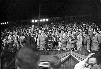 Remise du trophée par les personnalités officielles lors de l'arrivée du Tour de France le 25 juillet 1948 en « tribune Présidentielle ».