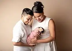 Un homme et une femme souriant et tenant leur nouveau né