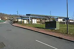 La rue du Treuil avec un poste électrique et des panneaux photovoltaïques au-dessus d'un parking