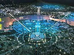 Vue nocturne sur l'axe des parlements (maquette) : le nouveau parlement au premier plan, puis l'ancien. Derrière le lac Burley Griffin se dessine Anzac Parade, menant à l’Australian War Memorial.