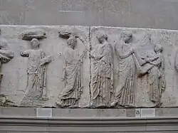 Frise située à l'est représentant trois femmes, un homme et un enfant tenant un tissu