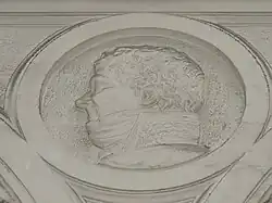 Bas-relief, la tête d'un homme de profil.