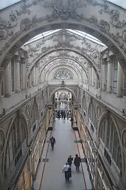 Arcade décorée, verrières, passerelles à rambarde, colonnes : le passage dans sa plus grande longueur.