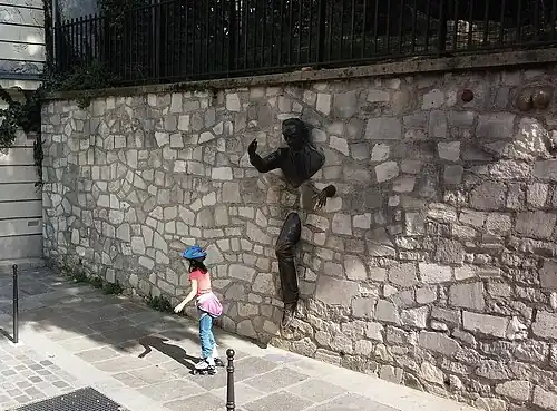 La sculpture de Jean Marais émergeant du mur.