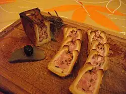 Pâté en croûte cocktail aux morilles, présenté tranché avec une olive posée sur un cornichon.