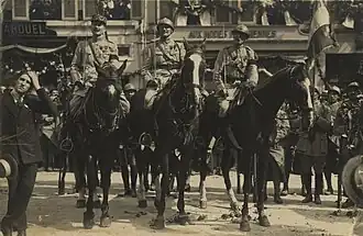 Photographie en noir et blanc de personnages montant des chevaux.