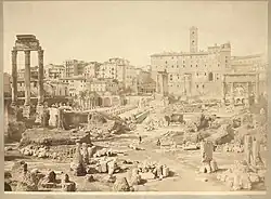 Photographie en noir et blanc d'un homme au milieu de ruines antiques.