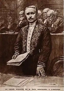 Dessin d’un homme se tenant debout, devant d’autres hommes : en habit vert d’académicien, il tient des feuilles dans sa main droite et semble discourir