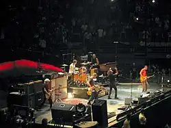 Cinq musiciens se partageant une scène.