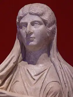Détail d'une statue de femme en toge, avec un voile sur la tête et tombant sur les épaules.