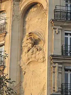 Décor Art Nouveau pour un cadran solaire sur la hauteur de 4 étages d'un immeuble rue Perrée à Paris (3eme arr) : en haut une femme représente l'aurore et en bas, le soir est figuré par une femme dont le visage est caché par un voile.