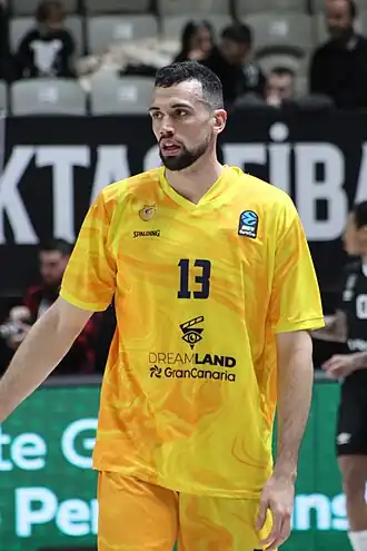 Un joueur de handball avec un maillot jaune portant le numéro 13