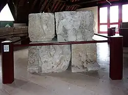 Photographie en couleurs d'un assemblage de blocs sculptés représentant des personnages.