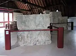 Photographie en couleurs d'un assemblage de blocs sculptés représentant des personnages.