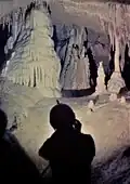 Homme devant une stalagmite