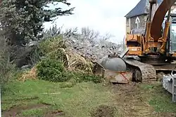 Photo d'une pelleteuse et de gravât de béton.
