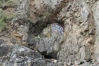 Photo de la sortie d'un tunnel dans une falaise.