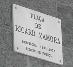 Photographie d'un panneau blanc, indiquent la place Ricardo-Zamora.