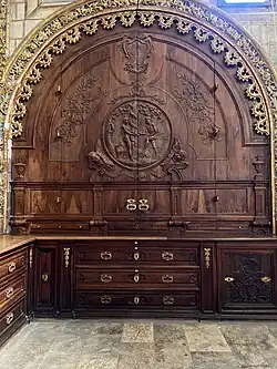 Placard sculpté à droite du retable au fond de la sacristie.