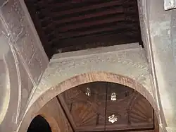 Photographie d'une partie du plafond en bois à solives apparentes de la nef centrale de la salle de prière.